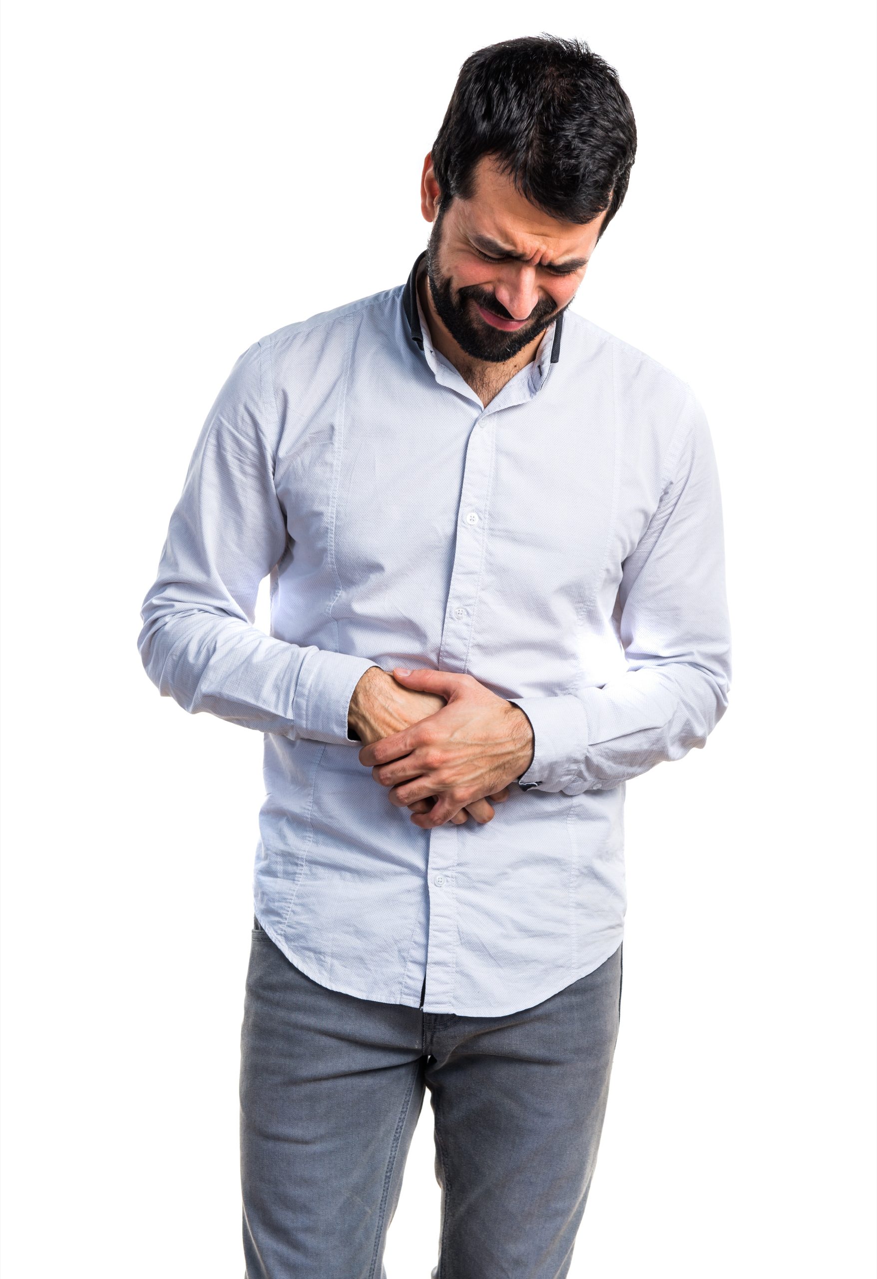 front view of a black haired man in a white shirt holding his stomach due to gastric cancer pain