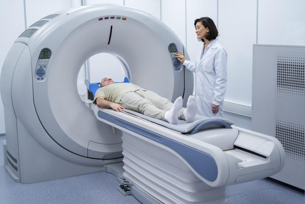 Patient undergoing radiation therapy with lady doctor next to him