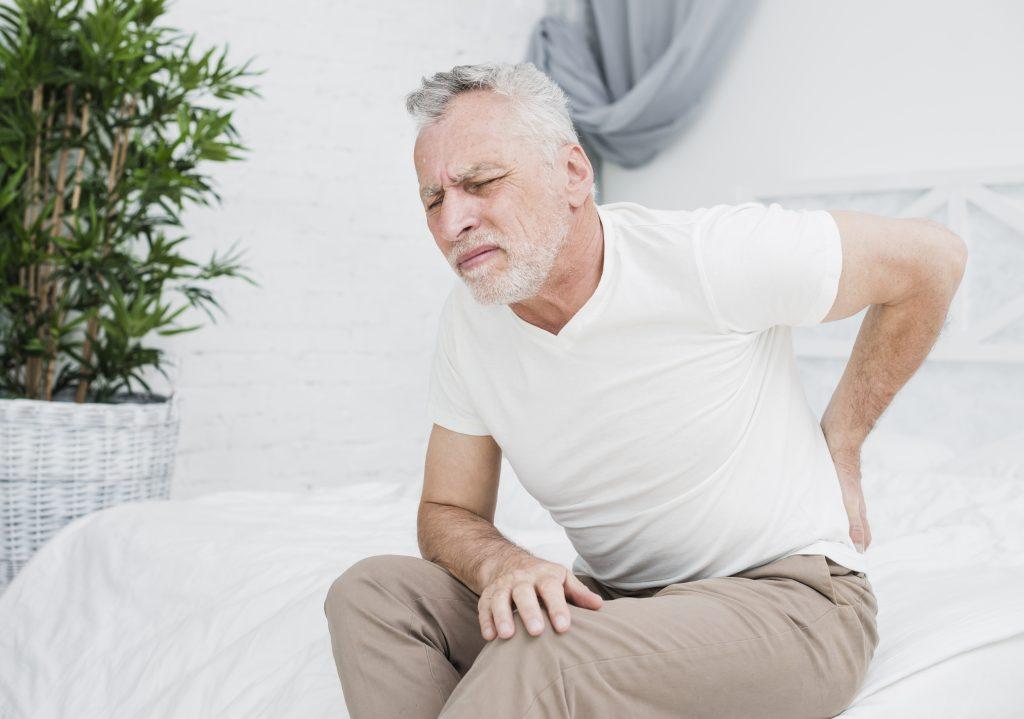 Old man suffering from back pain due to chronic pancreatitis
