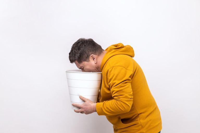 Man vomiting in a yellow hoodie