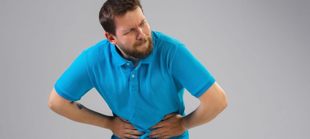 A young man is feeling pain because of constipation.
